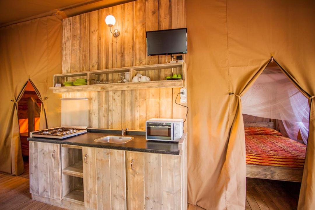Gemütliche Holzküche mit Betten, die durch Vorhänge getrennt sind.