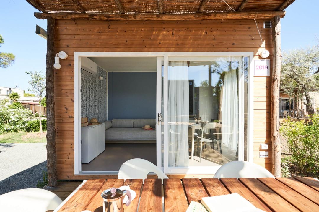 Accogliente bungalow in legno con terrazza e giardino.