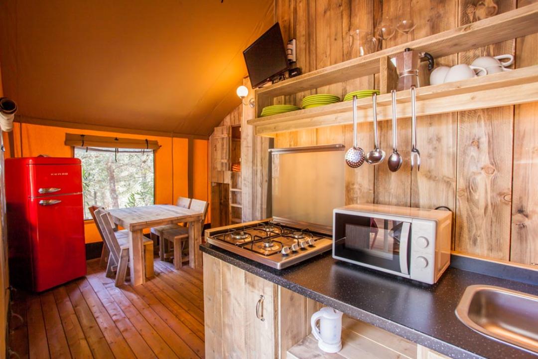 Rustikale Küche mit Esstisch, rotem Kühlschrank und Küchenutensilien.