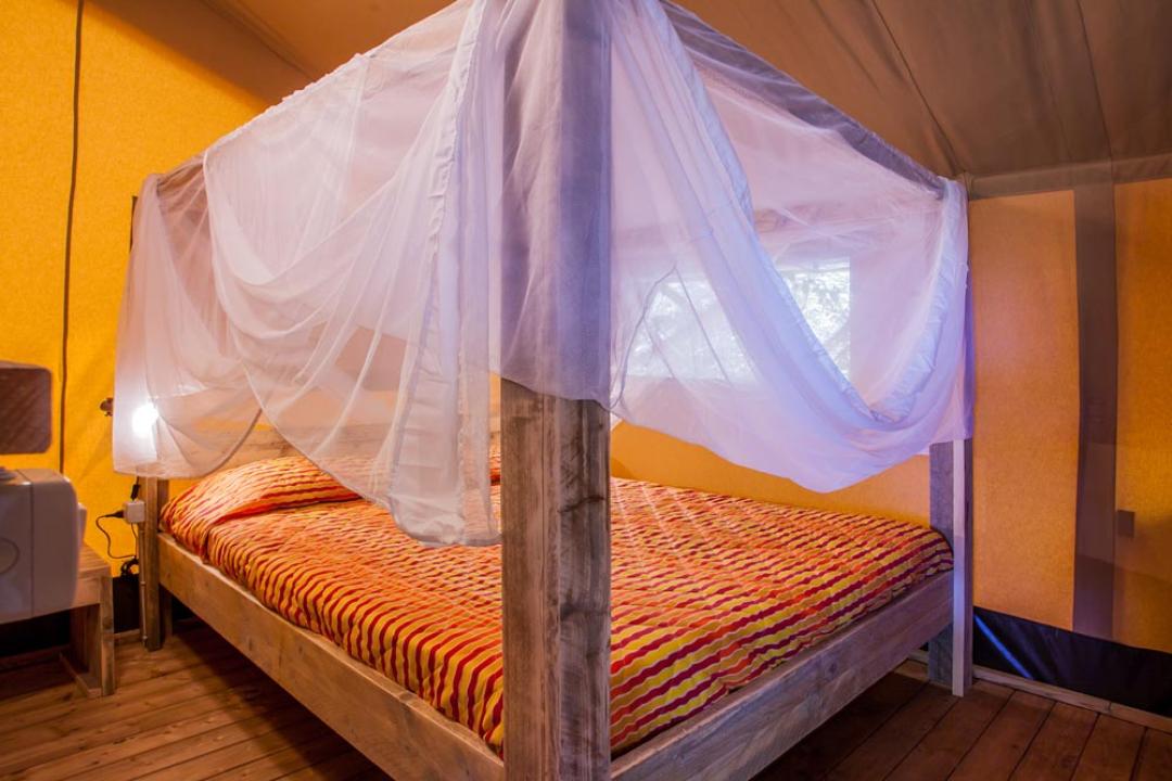Łóżko z baldachimem i moskitierą w przytulnym pokoju.