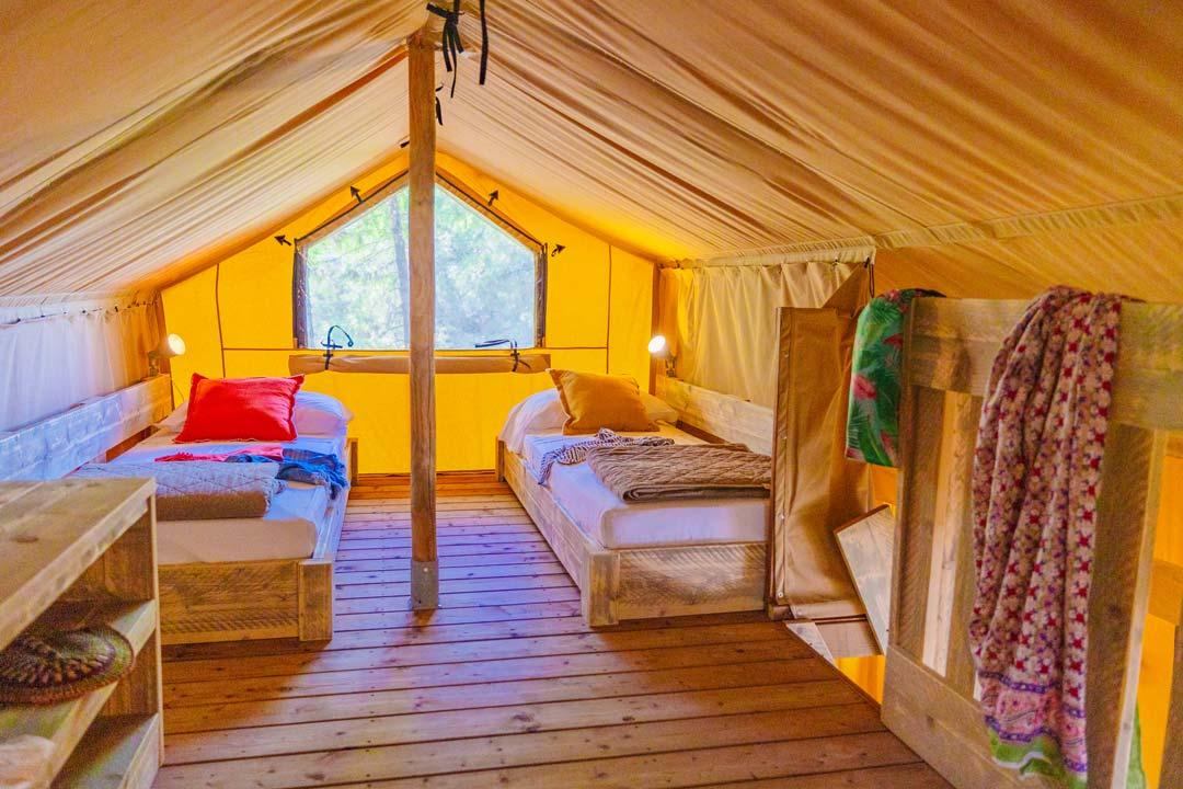 Namiot glampingowy z dwoma pojedynczymi łóżkami, jasny i przytulny.