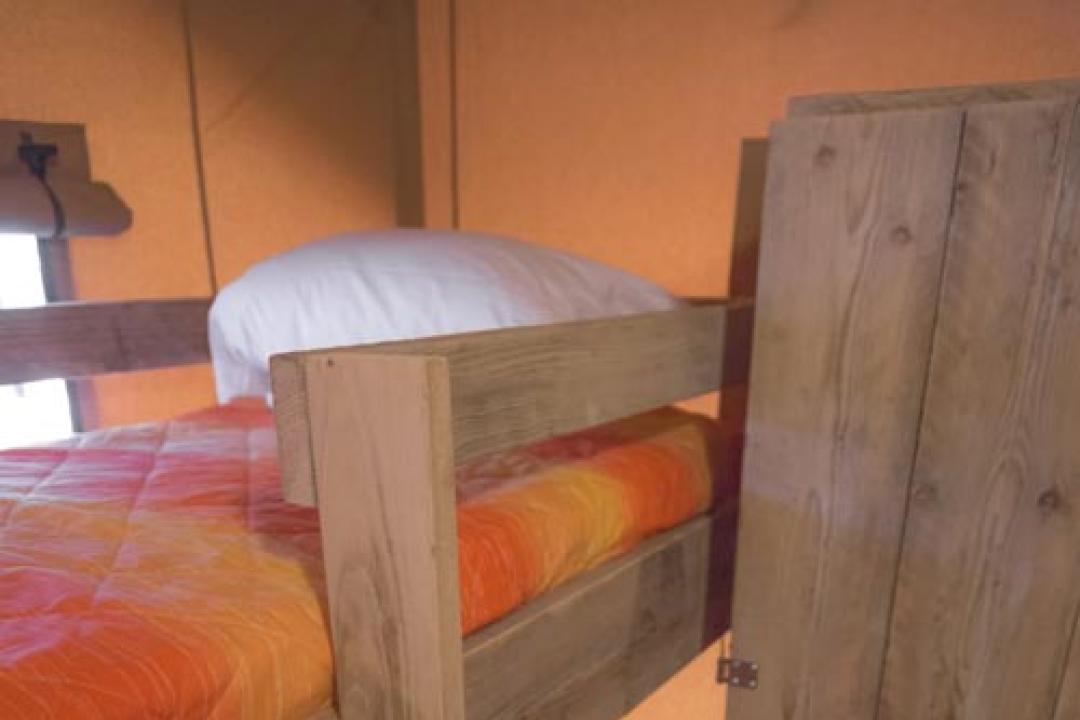 Drewniane łóżko piętrowe z szafą w przytulnym pokoju.